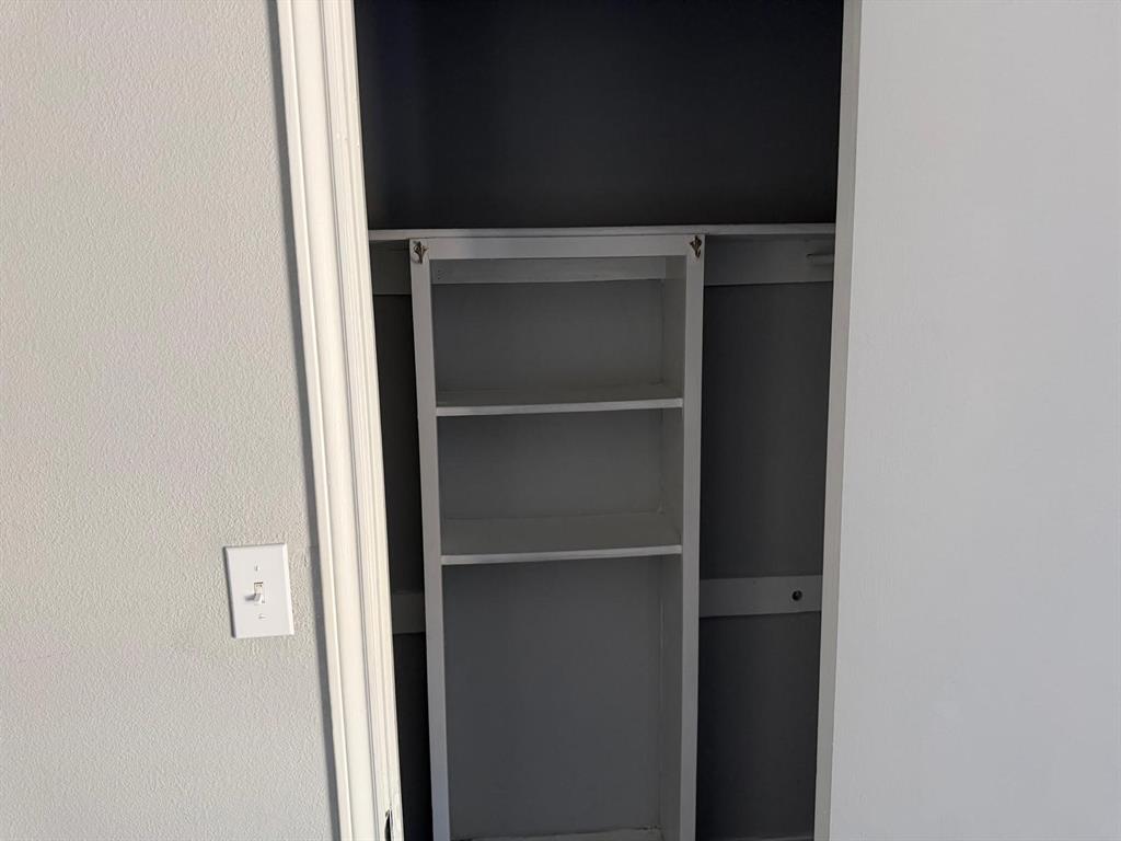 Built-in shelving unit with three storage compartments and an integrated hanging rod
