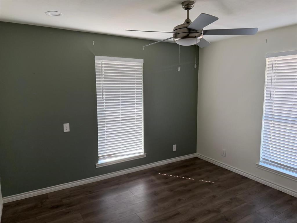 Wood-finish flooring, dual windows with blinds, contemporary ceiling fan, recessed lighting, and a two-tone wall treatment