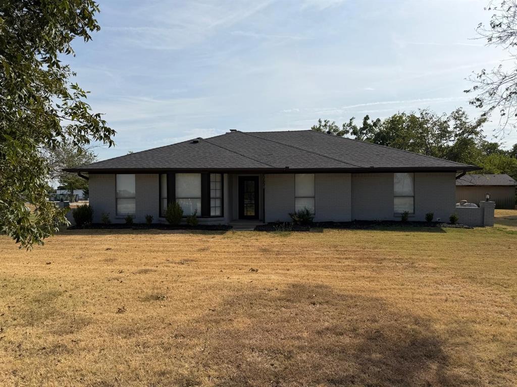 Single-story residence featuring a dark asphalt shingle roof, gray exterior siding, and multiple front-facing windows Single-story residence featuring a dark asphalt shingle roof, gray exterior siding, and multiple front-facing windows