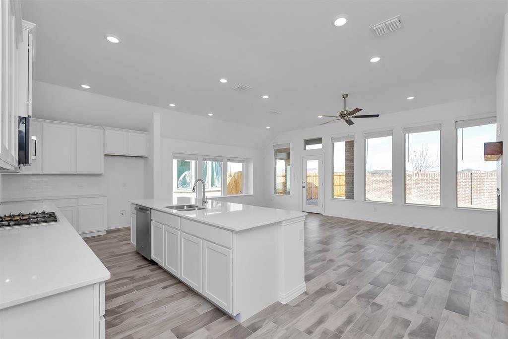Kitchen featuring appliances with stainless steel finishes, a ceiling fan, recessed lighting, open floor plan, and white cabinets Kitchen featuring appliances with stainless steel finishes, a ceiling fan, recessed lighting, open floor plan, and white cabinets