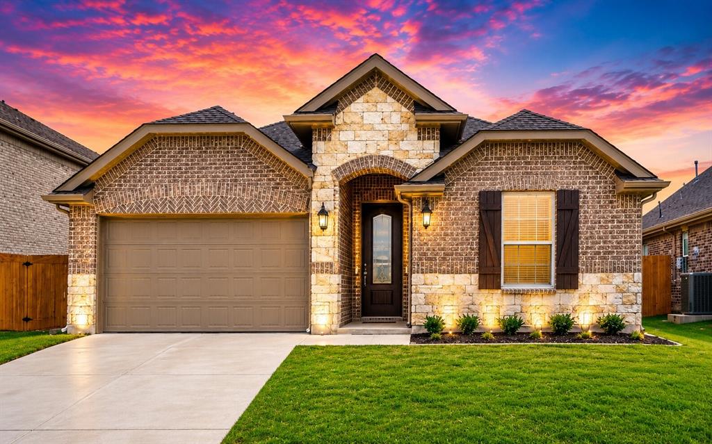 Front exterior featuring a brick and stone facade, an attached garage, a concrete driveway, and a front entry door with a glass insert Front exterior featuring a brick and stone facade, an attached garage, a concrete driveway, and a front entry door with a glass insert