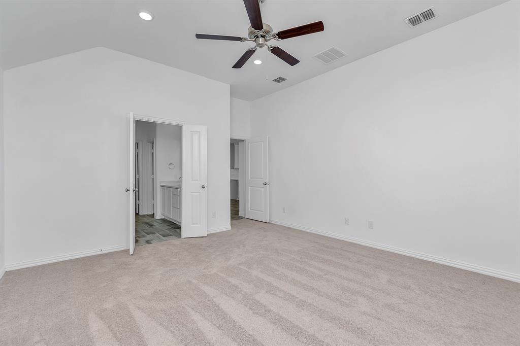 Unfurnished bedroom featuring light colored carpet, recessed lighting, lofted ceiling, connected bathroom, and ceiling fan