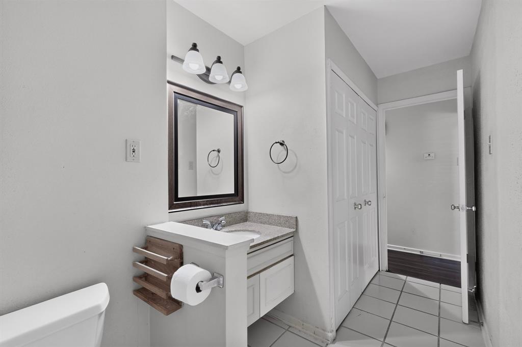 Bathroom featuring a vanity with an integrated sink, framed mirror, and a three-light fixture