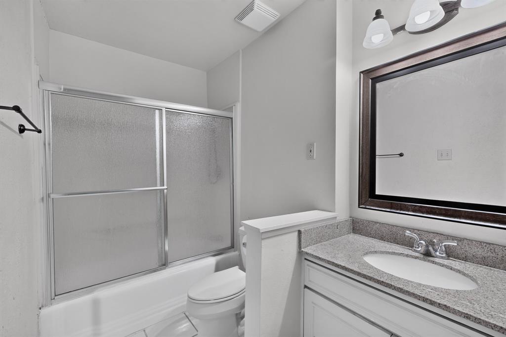 White vanity with a polished countertop, undermount sink, and chrome fixtures