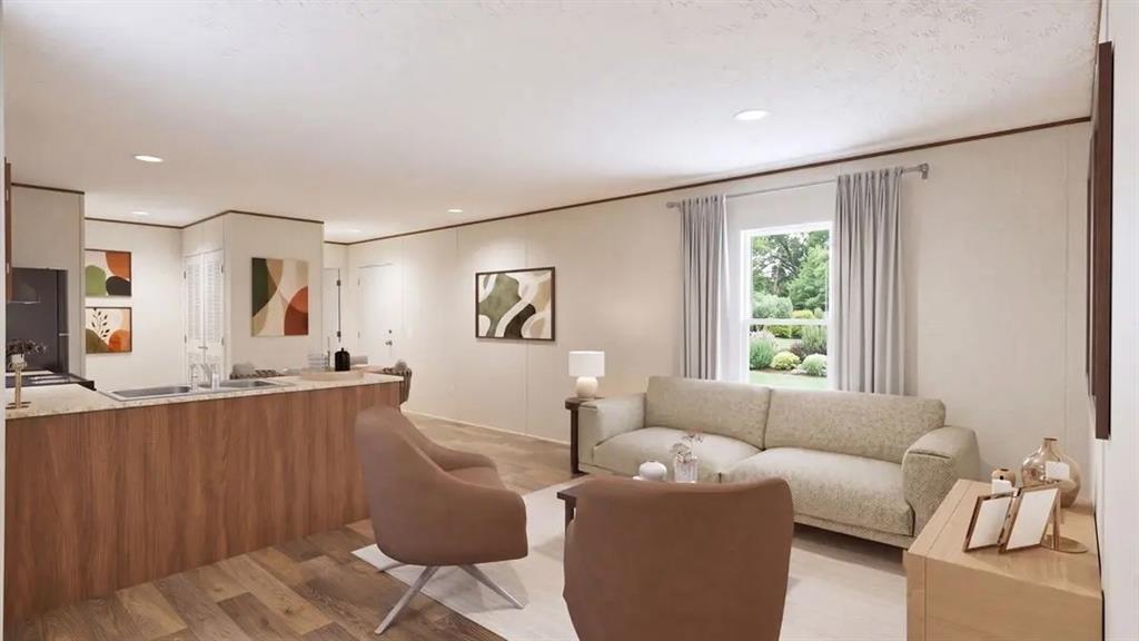 Open-concept interior featuring wood-finish flooring, recessed lighting, and a kitchen island with a stone-finish countertop