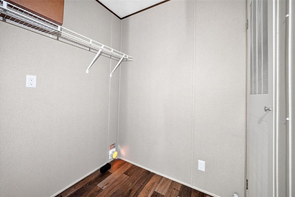Storage space featuring wood-finish flooring, a white wire shelving system, and a louvered door