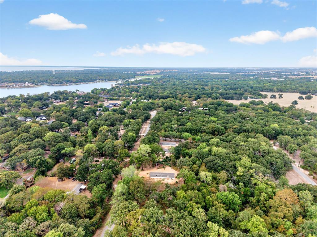 Aerial perspective featuring mature tree canopy, dense woodland acreage, and prominent water frontage
