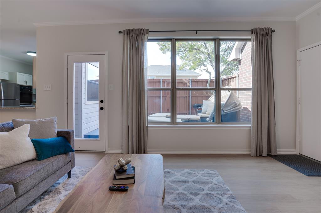 Light wood-finish flooring, a large multi-pane window, and a glass-paneled door provide ample natural illumination