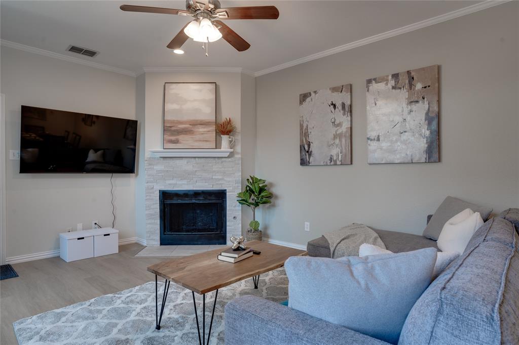 Living area with a corner fireplace featuring a stone surround and a mantel