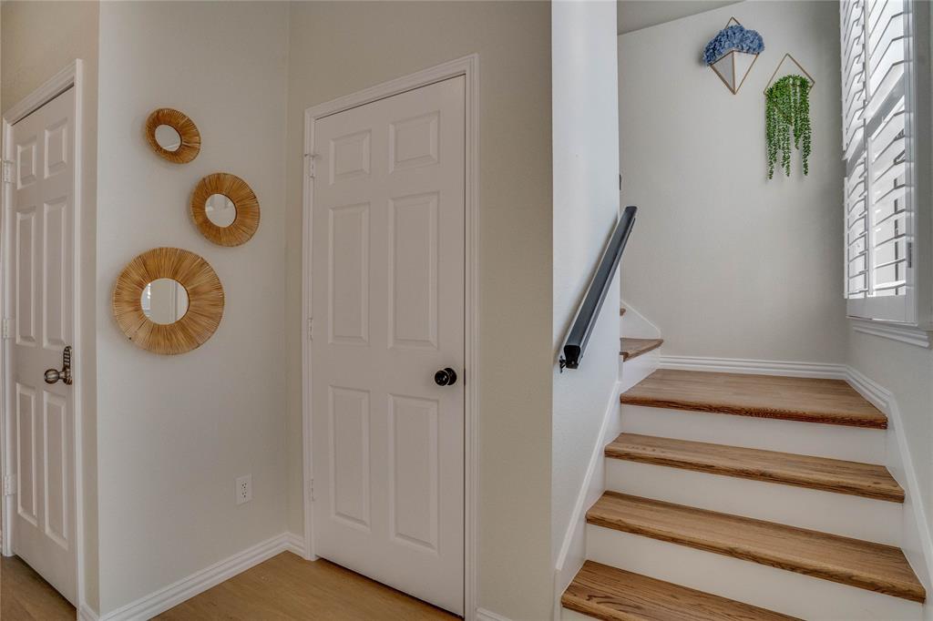 Hardwood treads, white risers, and a sleek black handrail define the staircase