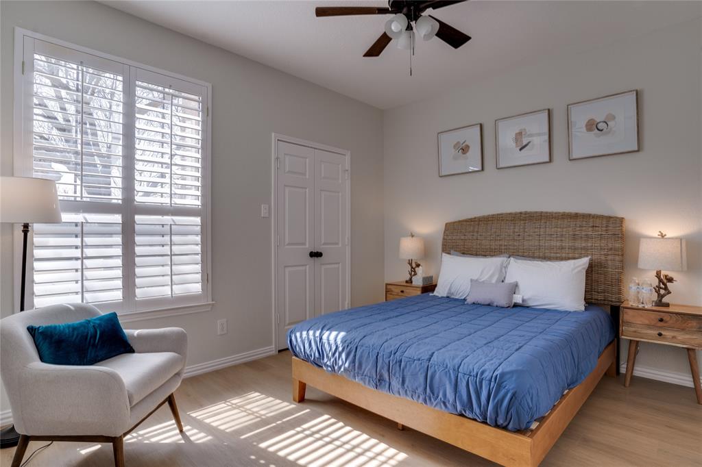 Wood-finish flooring, plantation shutters, ceiling fan, and built-in closet