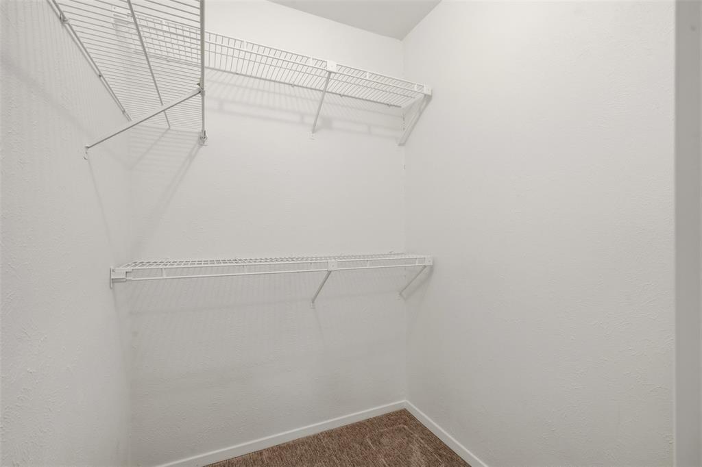 White wire shelving system with multiple tiers, textured white walls, and carpeting