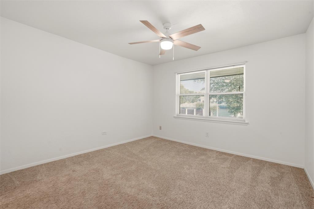 Bright corner bedroom with abundant natural light from dual windows, neutral wall finishes, and ceiling fan with integrated lighting
