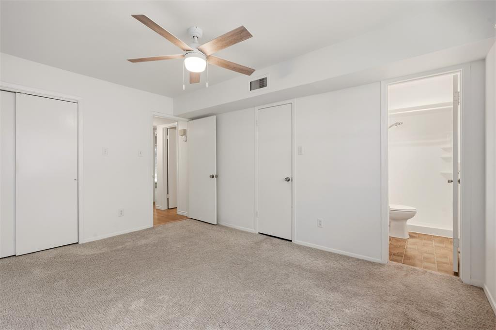 Wall-to-wall carpet flooring, ceiling fan with integrated lighting, and white bi-fold closet doors