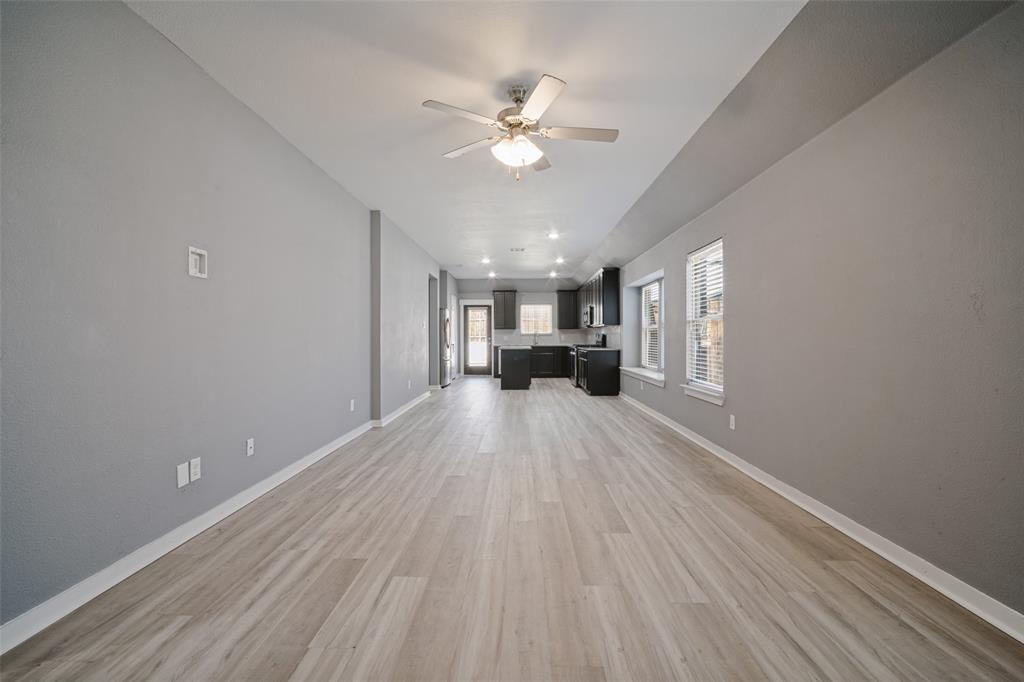 Open-concept interior featuring wood-finish flooring, vaulted ceilings with a centered ceiling fan, and recessed lighting Open-concept interior featuring wood-finish flooring, vaulted ceilings with a centered ceiling fan, and recessed lighting