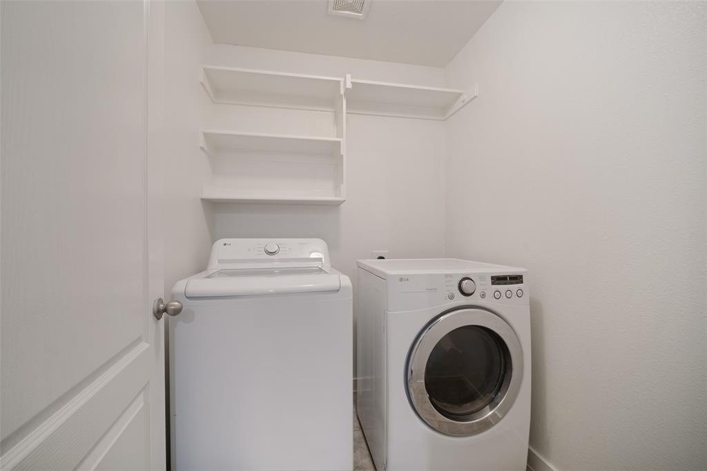 Laundry area featuring white built-in wall shelving