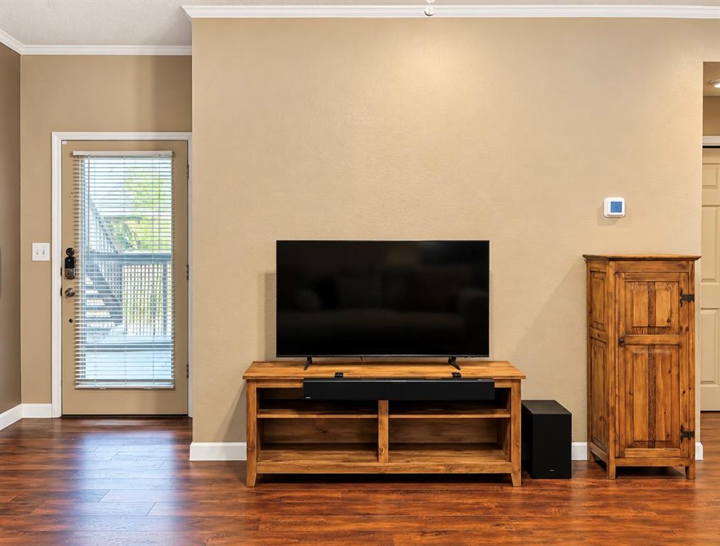 Hardwood-style flooring throughout with white crown molding and baseboards