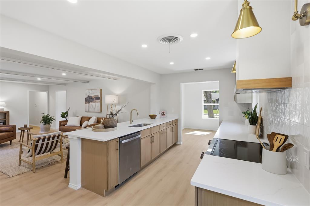 Kitchen featuring light-finish cabinetry, white countertops, a tiled backsplash, wood-finish flooring, and gold-tone pendant lighting