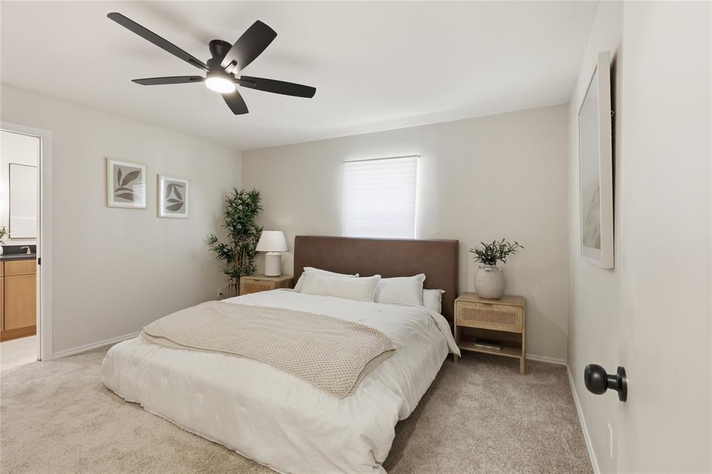 Neutral-toned interior featuring wall-to-wall carpeting and a multi-blade ceiling fan with integrated lighting