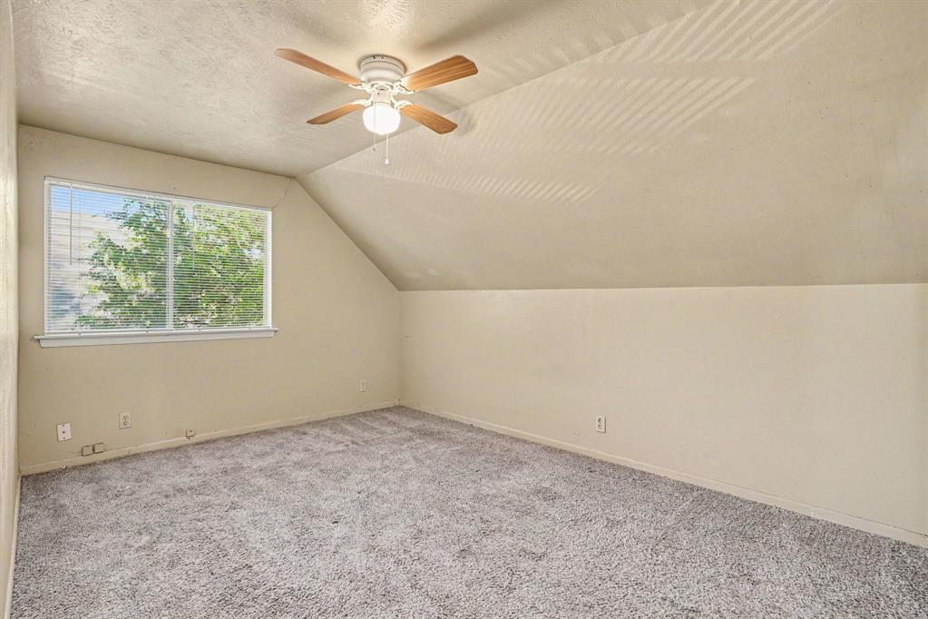 Carpeted flooring, sloped ceiling, window with blinds, ceiling fan with light fixture