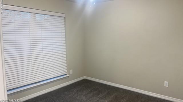 Recessed window with horizontal blinds, neutral wall paint, and gray carpet
