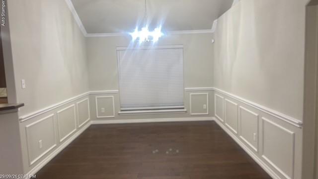 Vaulted ceiling with crown molding, wood-finish flooring, accent wainscoting, and a window with blinds