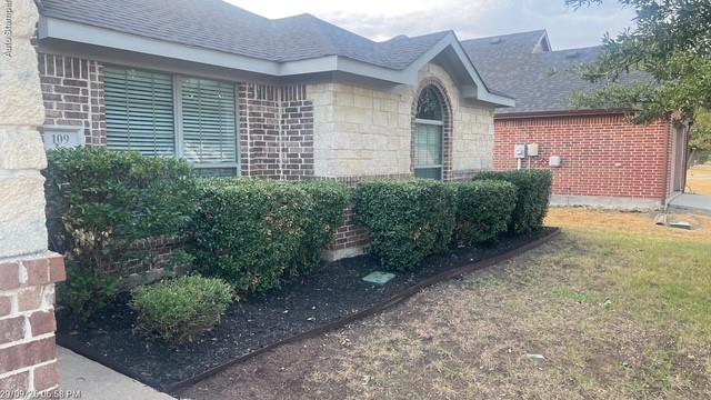 Brick and stone exterior with architectural shingles and arched window