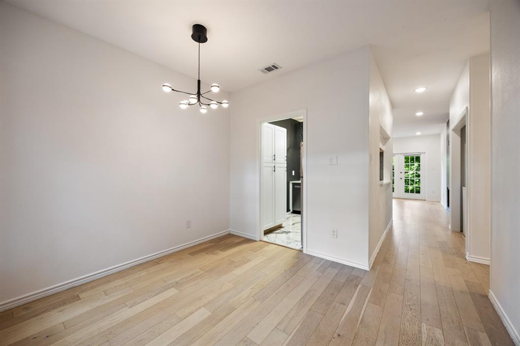Recessed lighting, wood-finish flooring, contemporary chandelier, white cabinetry, and a glass-paneled exterior door