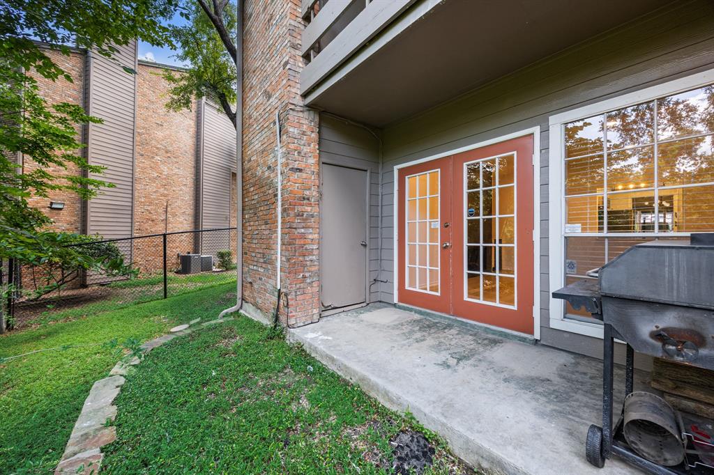 Red-framed French doors, large picture window, and a concrete patio space