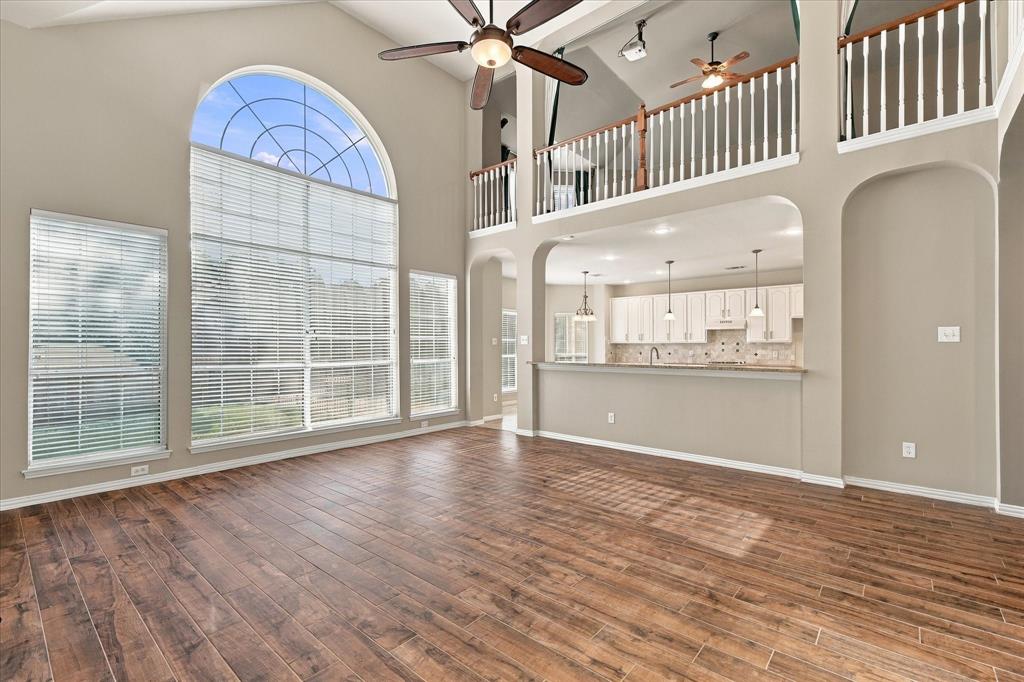 THE PERFECT BLEND OF DRAMA AND FUNCTION! A magnificent arched window floods the impressive two-story living room with natural light, while the open kitchen overlooks the main gathering space. Architectural elegance and effortless flow create a truly remarkable setting.