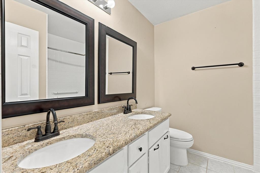 CLASSIC ELEGANCE MEETS EVERYDAY CONVENIENCE! Beautiful granite countertops, dual sinks, rich dark-framed mirrors, and contrasting fixtures create a polished bathroom with plenty of space for daily routines.