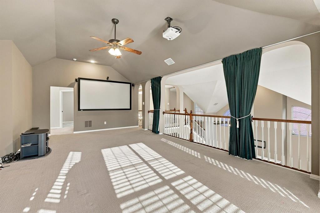 THE ULTIMATE ENTERTAINMENT DESTINATION! A dramatic vaulted ceiling, impressive projection screen, and open balcony overlooking the living spaces below make this versatile upstairs retreat ideal for movie nights, entertaining, and relaxing in style.