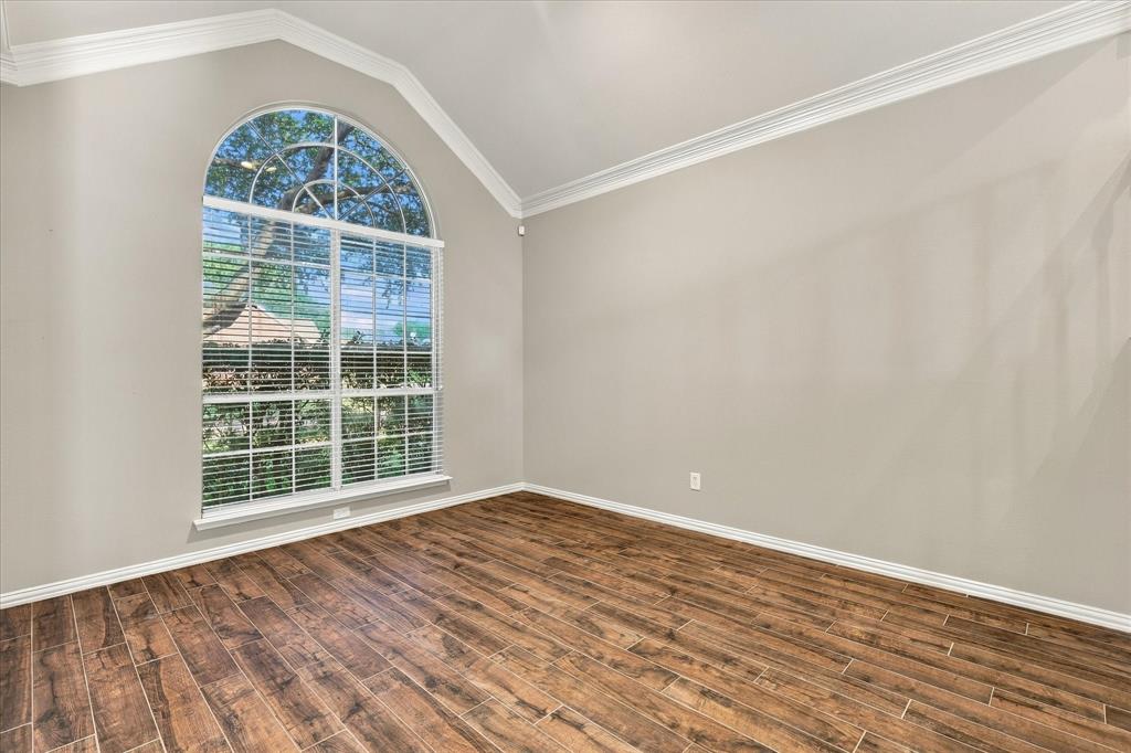 SOPHISTICATION IN EVERY DETAIL! A magnificent arched window, soaring ceiling, beautiful crown molding, and rich wood-look tile flooring create an elegant setting for refined entertaining, intimate conversations, or a wonderful home office.