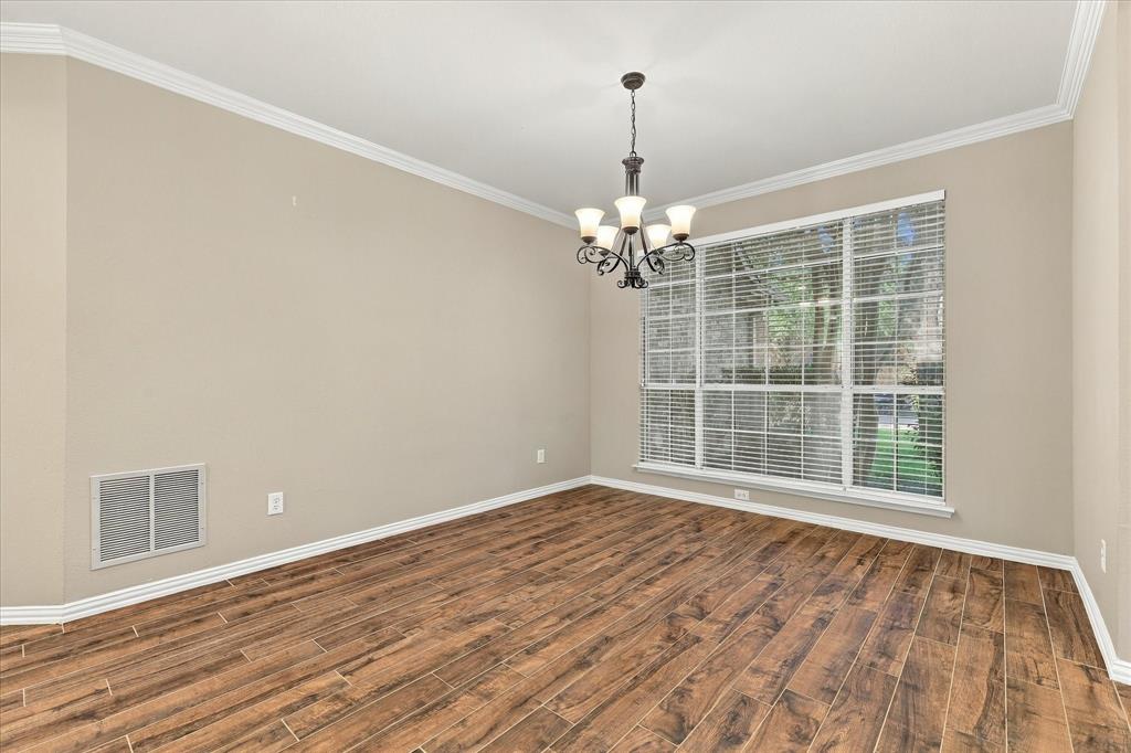 WHERE UNFORGETTABLE GATHERINGS BEGIN! This spacious formal dining room offers timeless elegance with gorgeous flooring, graceful crown molding, a classic chandelier, and an expansive window overlooking the mature landscaping.