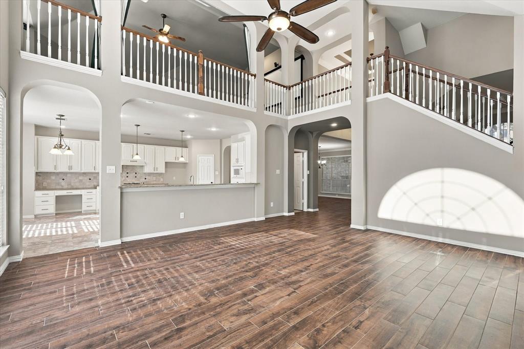 DESIGNED TO IMPRESS AND ENTERTAIN! Dramatic two-story ceilings, graceful architectural columns, elegant archways, and a sweeping upstairs gallery create an unforgettable open living environment. Seamless access to the kitchen makes this space ideal for gatherings both large and small.