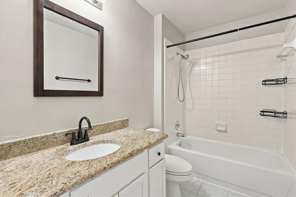 CLASSIC ELEGANCE & EVERYDAY COMFORT! Gorgeous granite countertops, rich dark fixtures, a beautifully framed mirror, and a crisp white tiled tub and shower create an inviting bathroom with timeless appeal.
