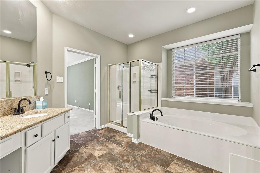 RELAXATION NEVER LOOKED SO INVITING! A beautiful soaking tub, separate glass-enclosed shower, frsh paint and sun-filled window create a serene escape, complemented by elegant granite countertops and timeless finishes