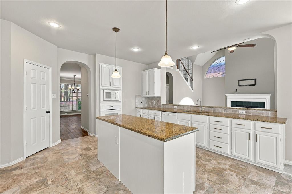 WHERE STYLE MEETS EVERYDAY LIVING! Gorgeous granite countertops, crisp white cabinetry, elegant pendant lighting, and an expansive center island create an inviting kitchen that flows effortlessly into the dramatic two-story living room.