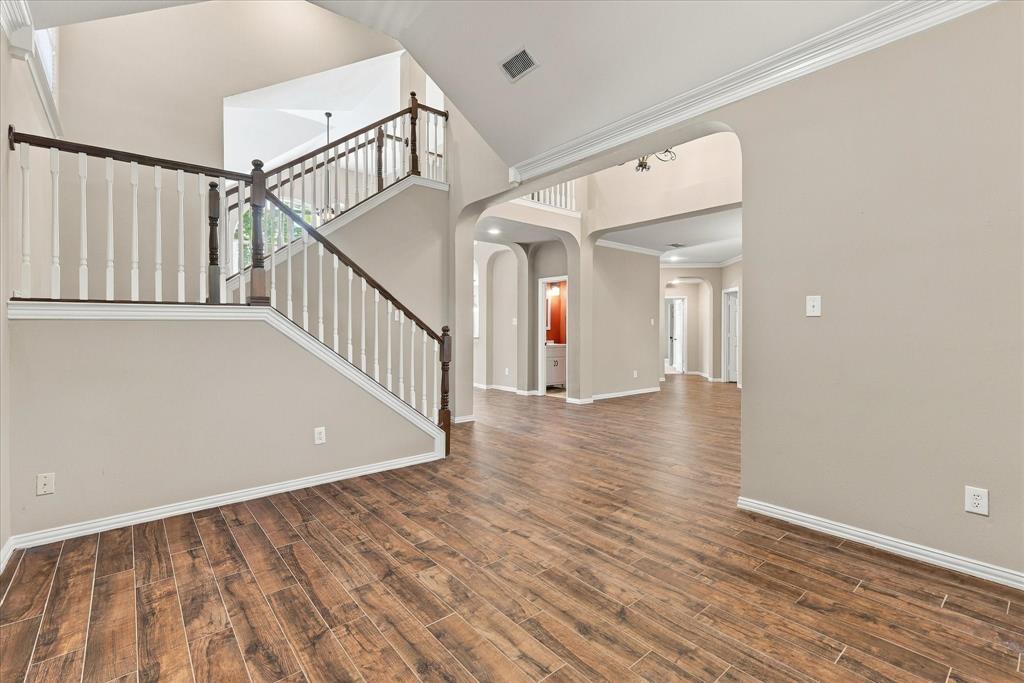 TIMELESS SOPHISTICATION! A magnificent arched window, graceful crown molding, soaring ceilings, and rich wood-look tile flooring create an elegant, sun-drenched living space. The perfect setting for stylish entertaining, a great home office or a peaceful retreat.