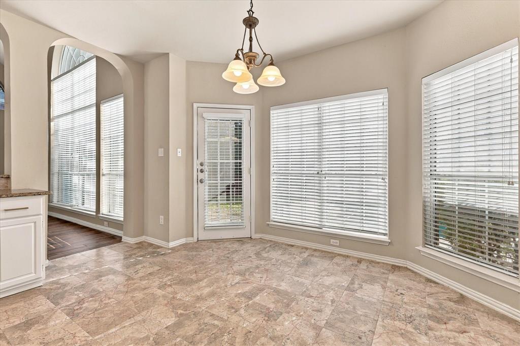 MORNINGS FEEL A LITTLE MORE MAGICAL HERE! Wrapped in natural light from oversized windows, this charming breakfast nook offers a delightful place to enjoy morning coffee, casual dining, and peaceful views of the outdoors.
