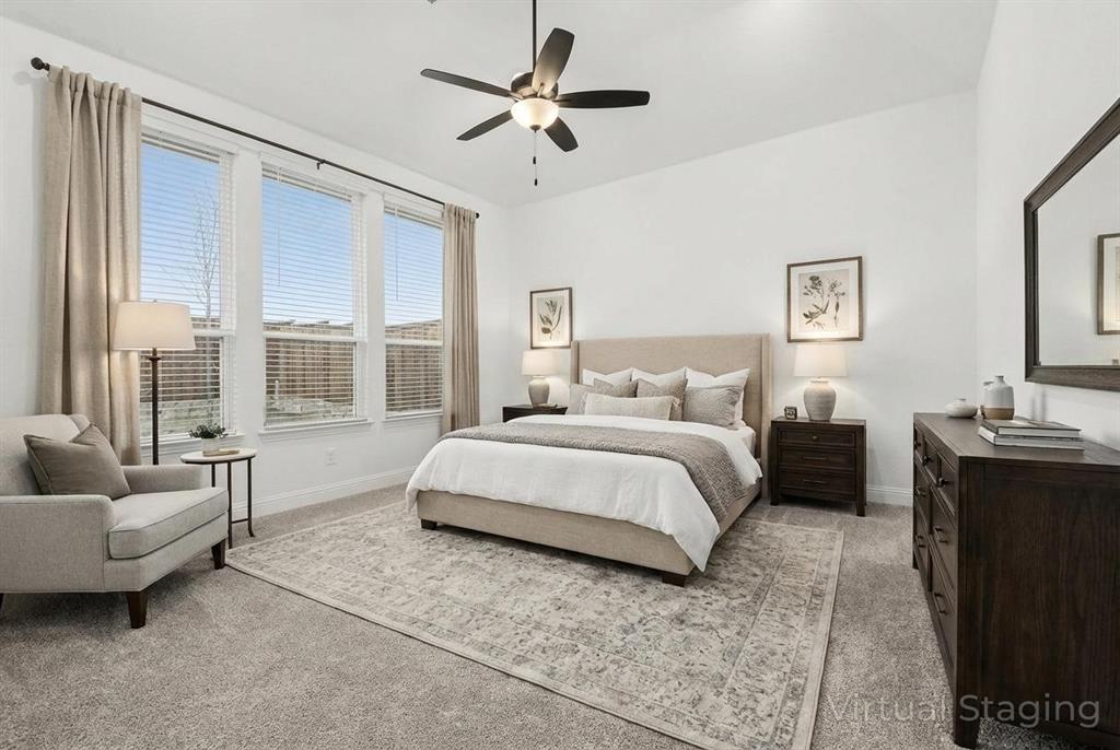 Vaulted ceilings, three large windows, neutral carpeting, and a multi-blade ceiling fan with integrated lighting