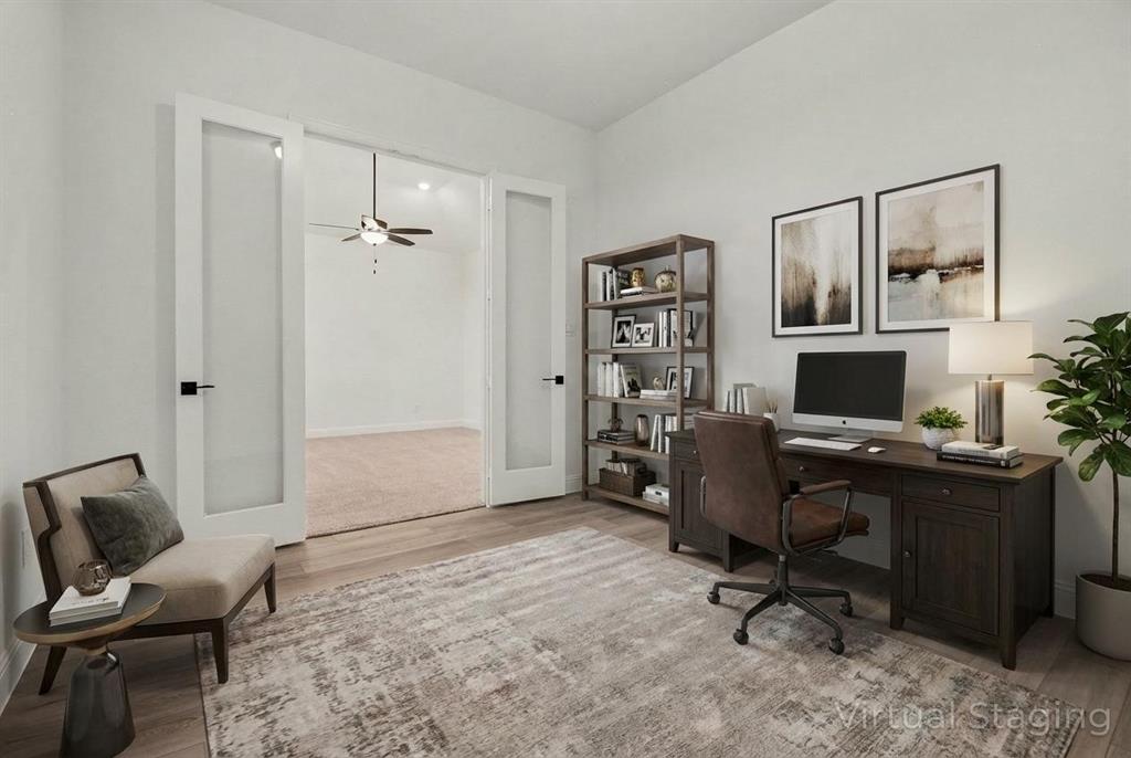 Interior room featuring neutral wall tones, high ceilings, wood-finish flooring, and double French doors with glass panes and matte black hardware