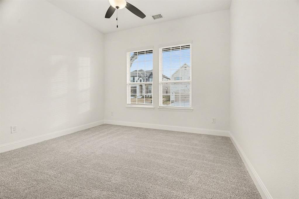 Room featuring neutral-toned carpeting, high ceilings, dual windows with blinds, and a built-in ceiling fan with light fixture