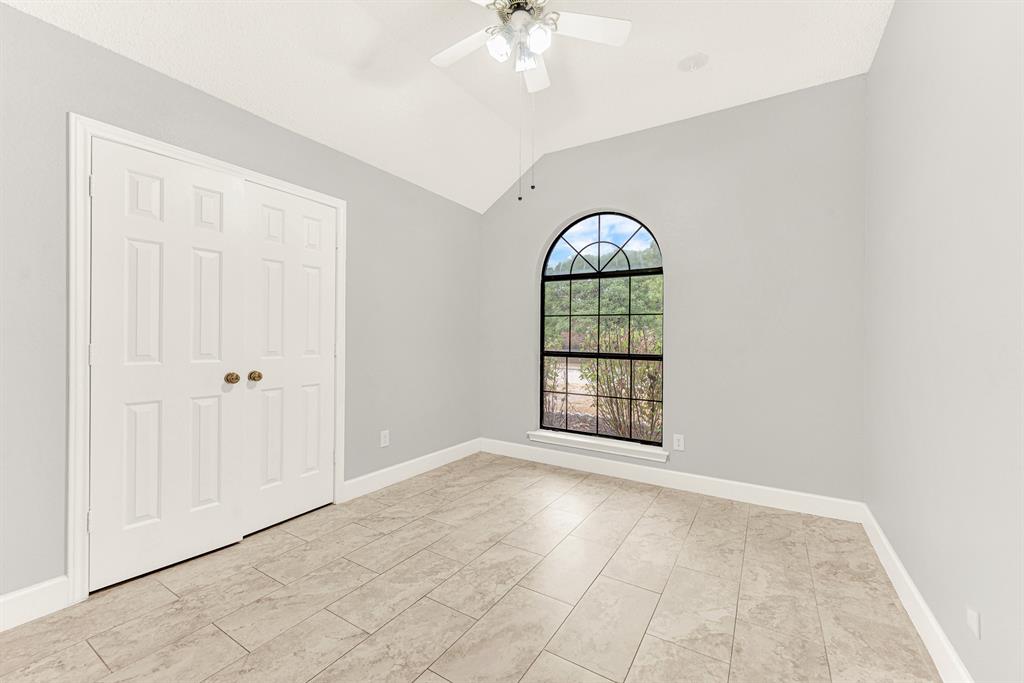 A grand arched window serves as a striking centerpiece, pouring natural daylight across the clean tiled floor. Imagine welcoming out-of-town loved ones into a bright, restful sanctuary where they can easily unpack and settle in