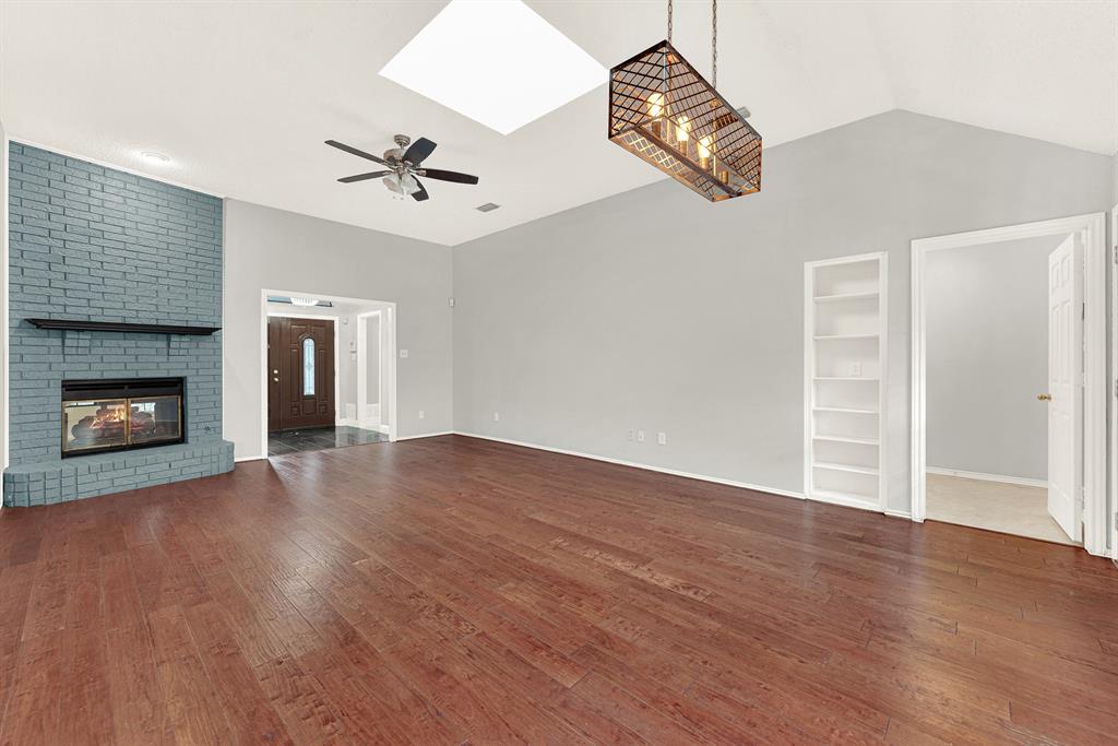 A central skylight pours bright sunshine directly onto rich, warm floors while built-in shelving adds subtle structural detail. You can easily envision styling a reading corner bathed in midday sunlight for quiet weekend afternoons.