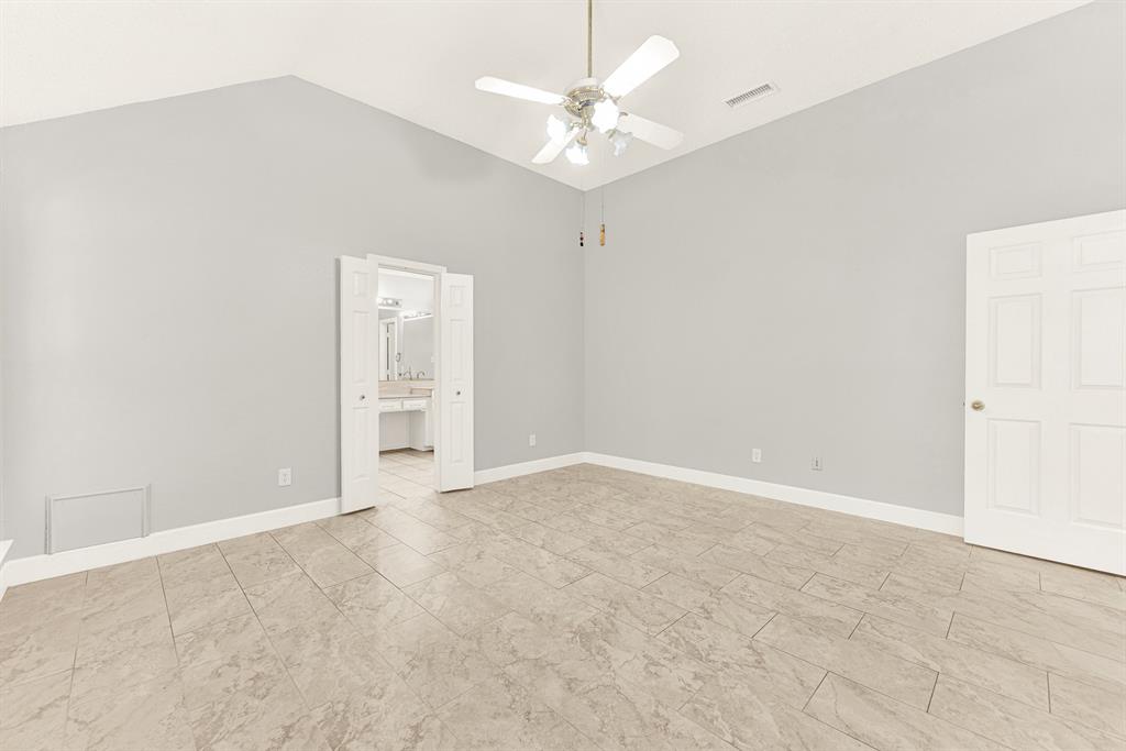 Double entry doors open seamlessly into the main bedroom, connecting high ceilings with effortless interior flow. You can easily picture slipping into comfortable loungewear after a long day in this tranquil space.