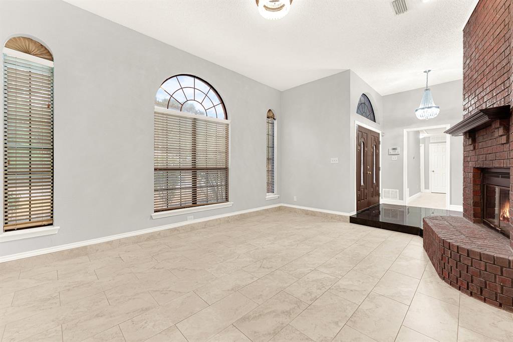 Sweeping tile floors reflect ambient light, effortlessly connecting the entry foyer to the main living area. You can easily envision welcoming guests through double doors for lively weekend dinner parties
