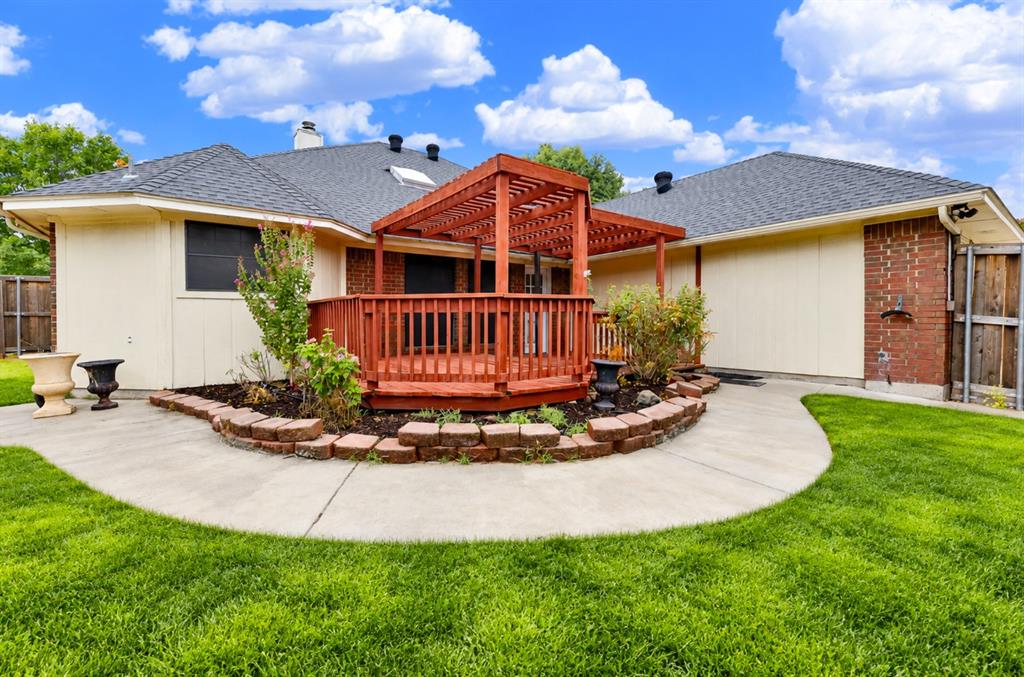 *digitally enhanced*  Curved stone landscaping beds wrap around the raised deck, showcasing structural appeal against the home’s roofline. Unwind here after work, watching evening colors settle over your private backyard oasis.