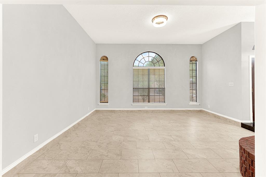 Symmetrical arched windows frame the back wall, creating a serene focal point that draws your eyes outward. Unwind here after a long day, watching the evening shadows softly lengthen across the quiet room