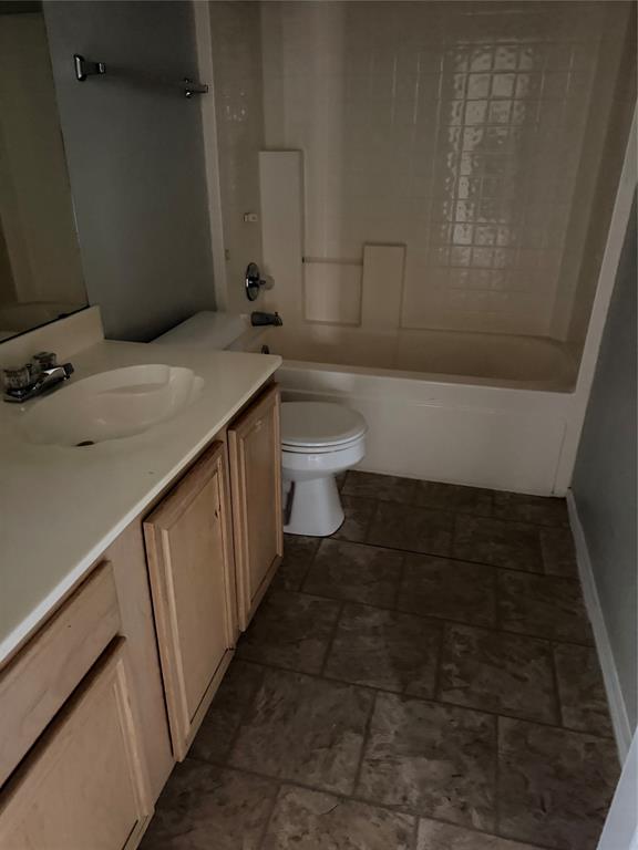 Tile flooring, wood-finish vanity with an integrated sink, and an enclosed bathtub with tile surround Tile flooring, wood-finish vanity with an integrated sink, and an enclosed bathtub with tile surround